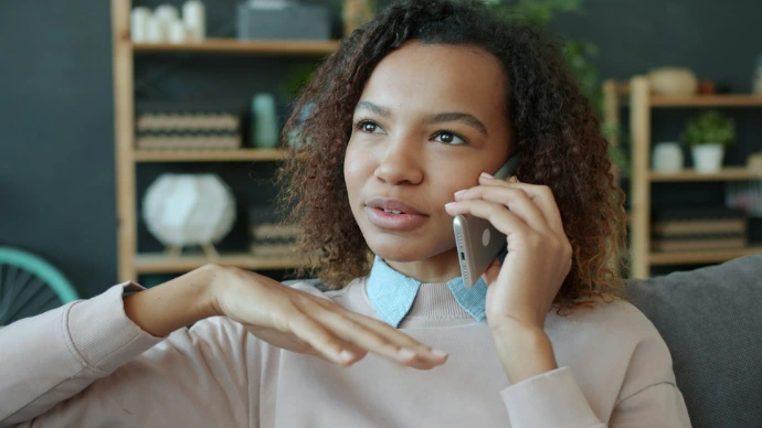 Young woman talking on a smartphone at home